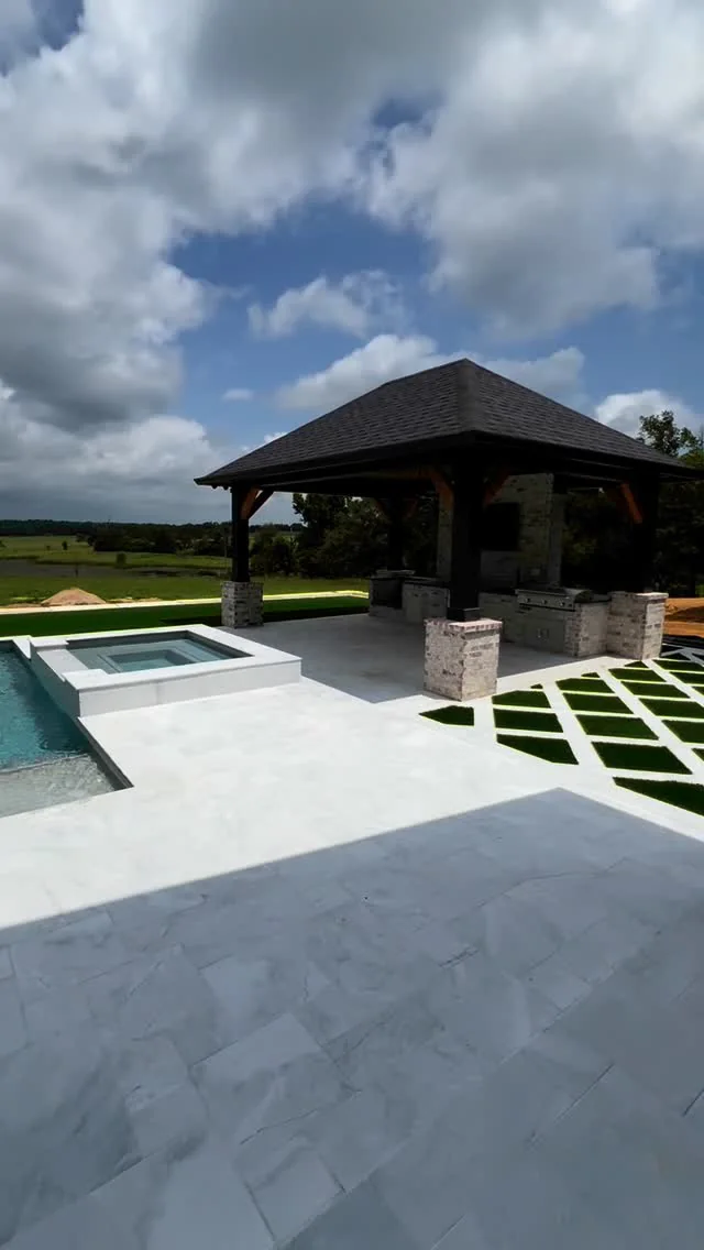 A pool and covered outdoor living area on a Tredway custom home