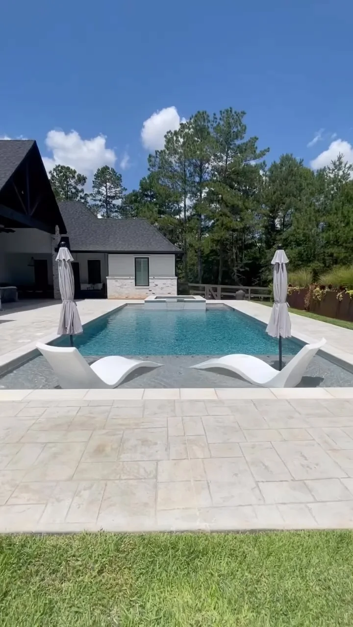 A pool and covered outdoor living area on a Tredway custom home